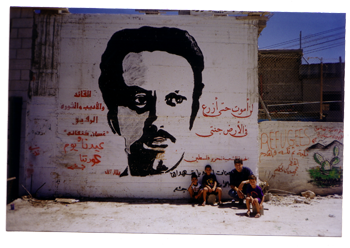 Arjan naast een portret van Ghassan Kanafani op een muur in Dheishe vluchtelingenkamp vlakbij Bethlehem, 2001.